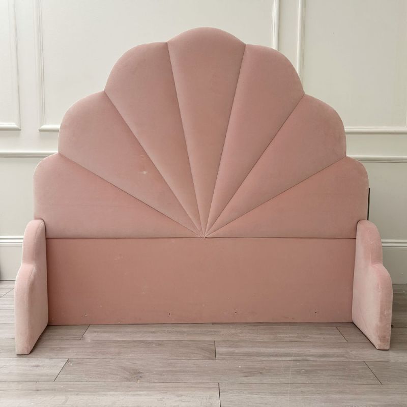 Shell shaped headboard upholstered with pink velvet
