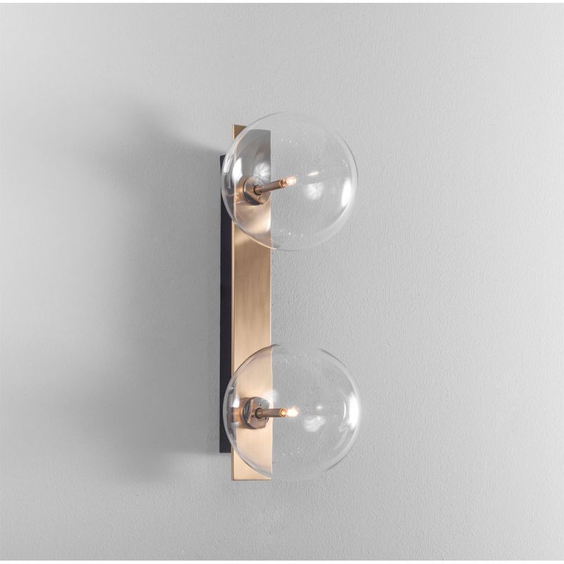 A chic, double light wall lamp with glass lampshades and a brass finish