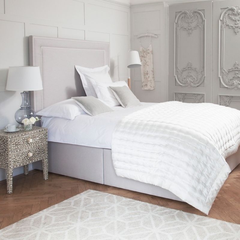 Luxury designer bed with tall headboard and piping detail