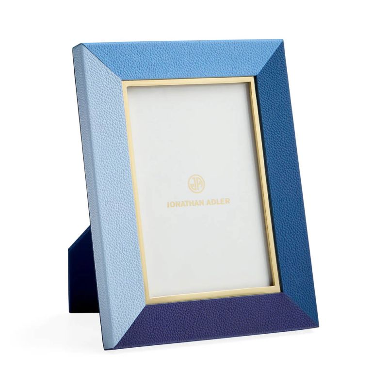 A tonal blue leather picture frame by Jonathan Adler with a glamorous polished brass inner edge