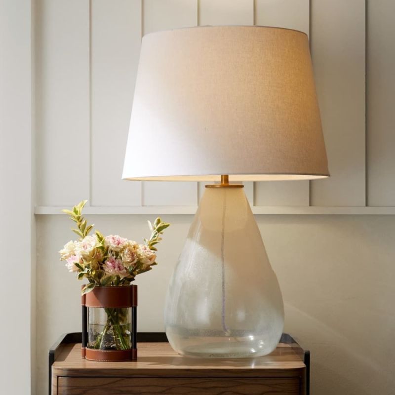 Illuminate your space with the Tiber Side Lamp in clear glass, blending modern elegance with functionality. Perfect for any room décor!