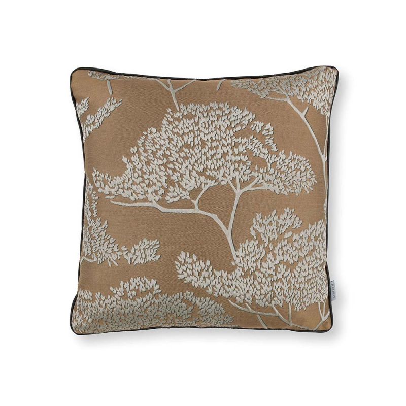 A copper coloured square cushion with cream coloured decorative trees
