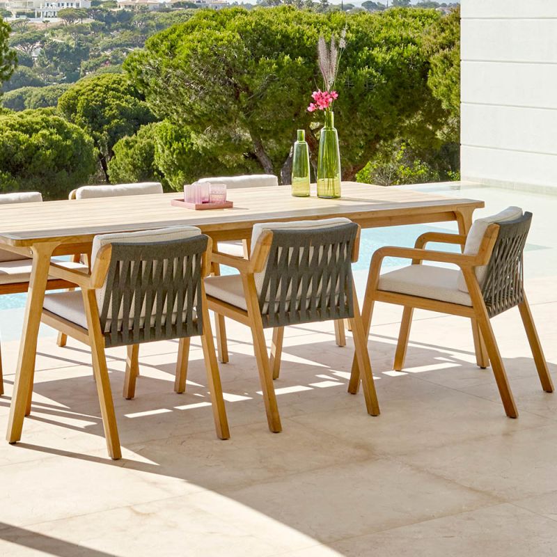 A stylish Scandinavian style outdoor dining chair with a stunning sunbrella cushion upholstery and natural frame