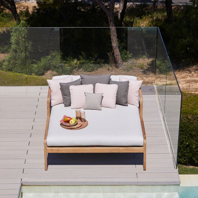 A luxury outdoor double day bed with a stylish sunbrella upholstery and natural base