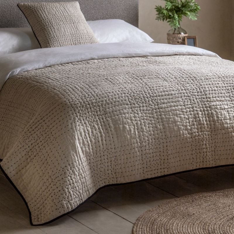 Beige quilted bedspread with black stitching
