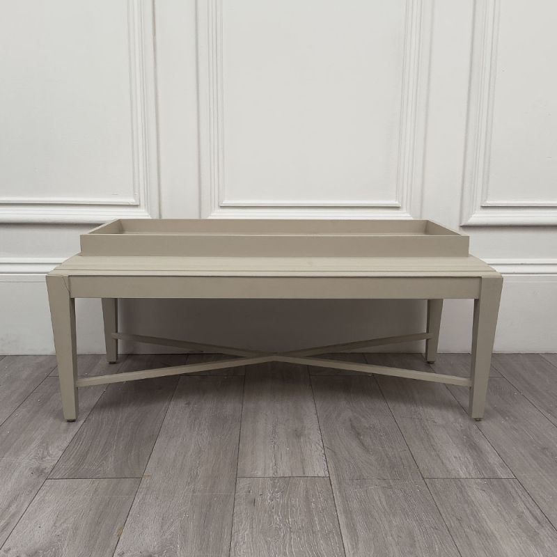 Pale grey table with four solid legs and a bordered top surface
