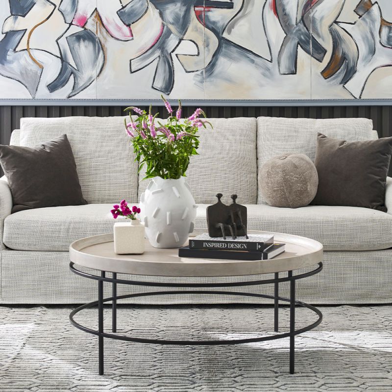 Round coffee table with a black metalwork frame and pale edged top