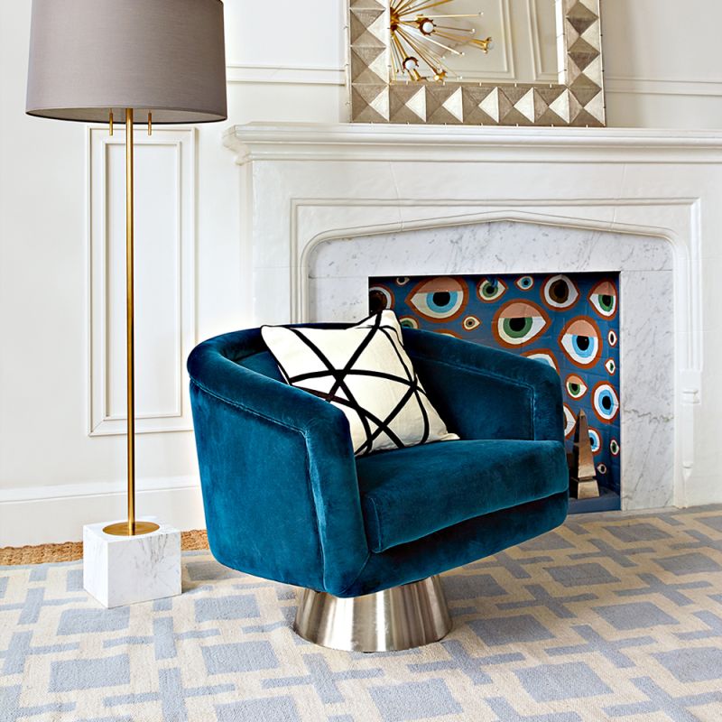 A luxurious blue velvet swivel chair with brushed stainless steel base