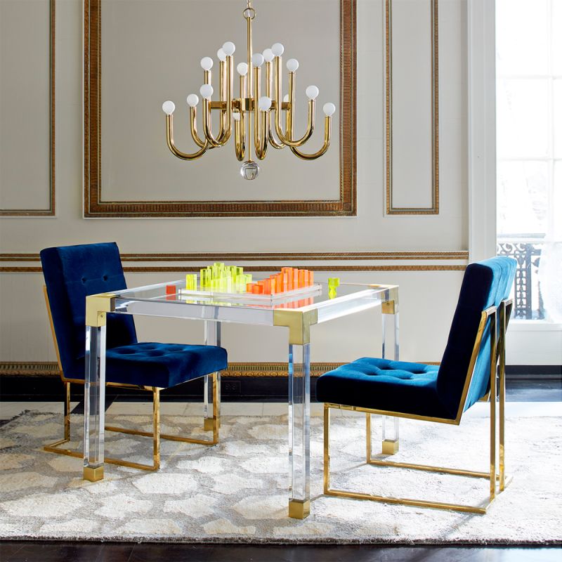 A contemporary brass and acrylic games tale with a glass surface