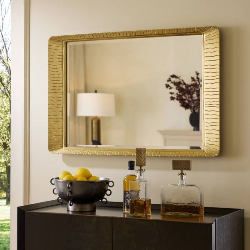 Rectangular mirror with antique brass frame featuring wave detailing