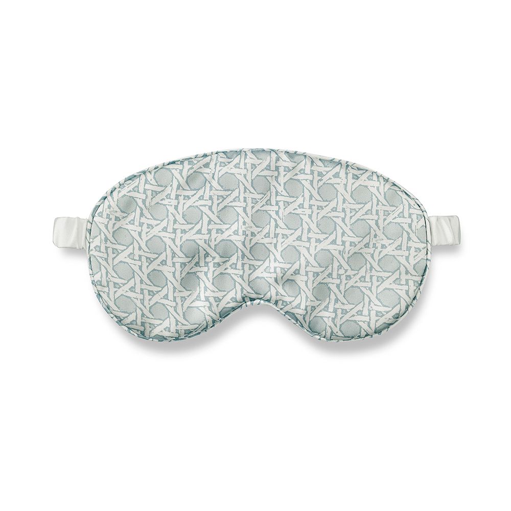 A glamorous silk eye mask with a rattan blue design on a gorgeous ivory background and complete with a drawstring pouch