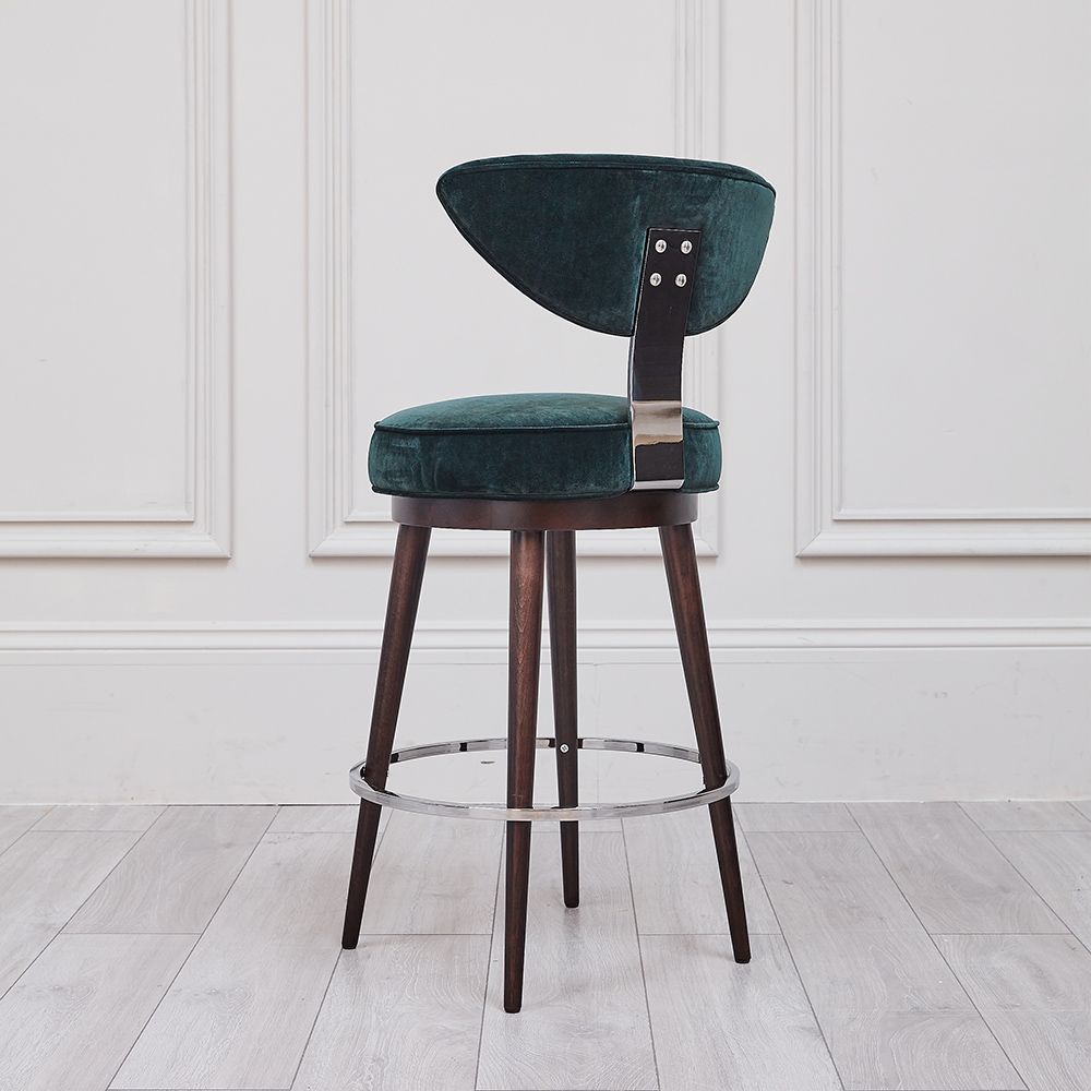 A luxurious, upholstered bar stool with tapered legs and silver accents