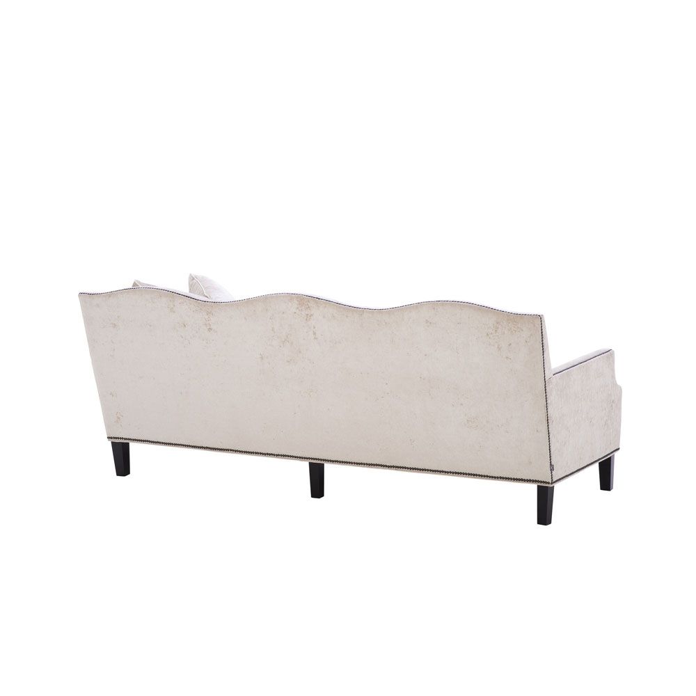 velvety off-white 3 seater sofa with bronze accents and black tapered legs 
