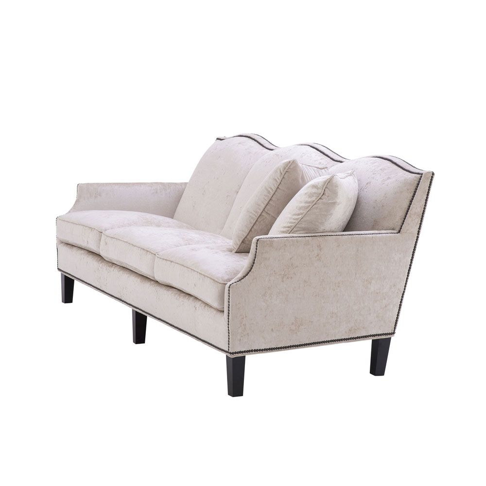 velvety off-white 3 seater sofa with bronze accents and black tapered legs 