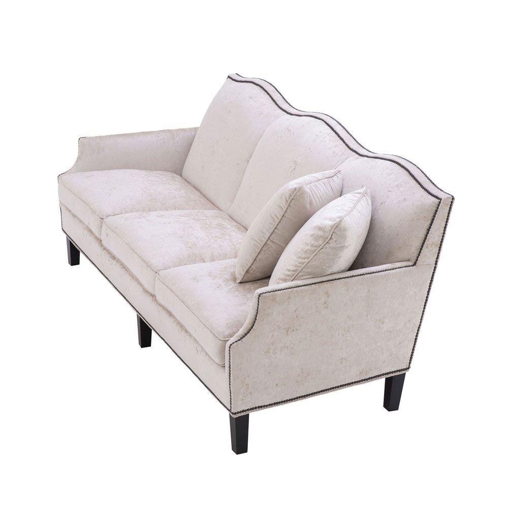 velvety off-white 3 seater sofa with bronze accents and black tapered legs 