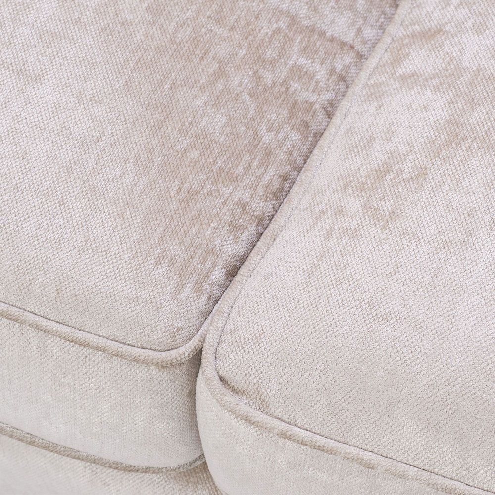 velvety off-white 3 seater sofa with bronze accents and black tapered legs 