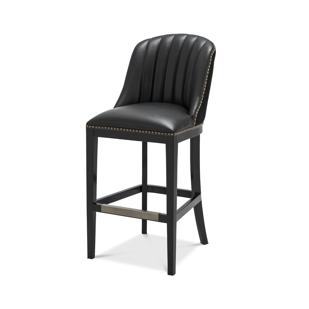 A chic black leather and velvet bar stool with antique brass studding