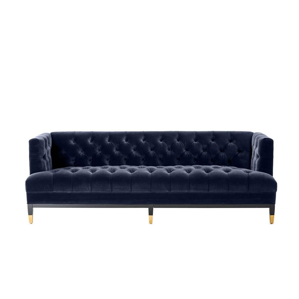 dark blue deep-buttoned sofa with velvet upholstery and black legs with gold accents