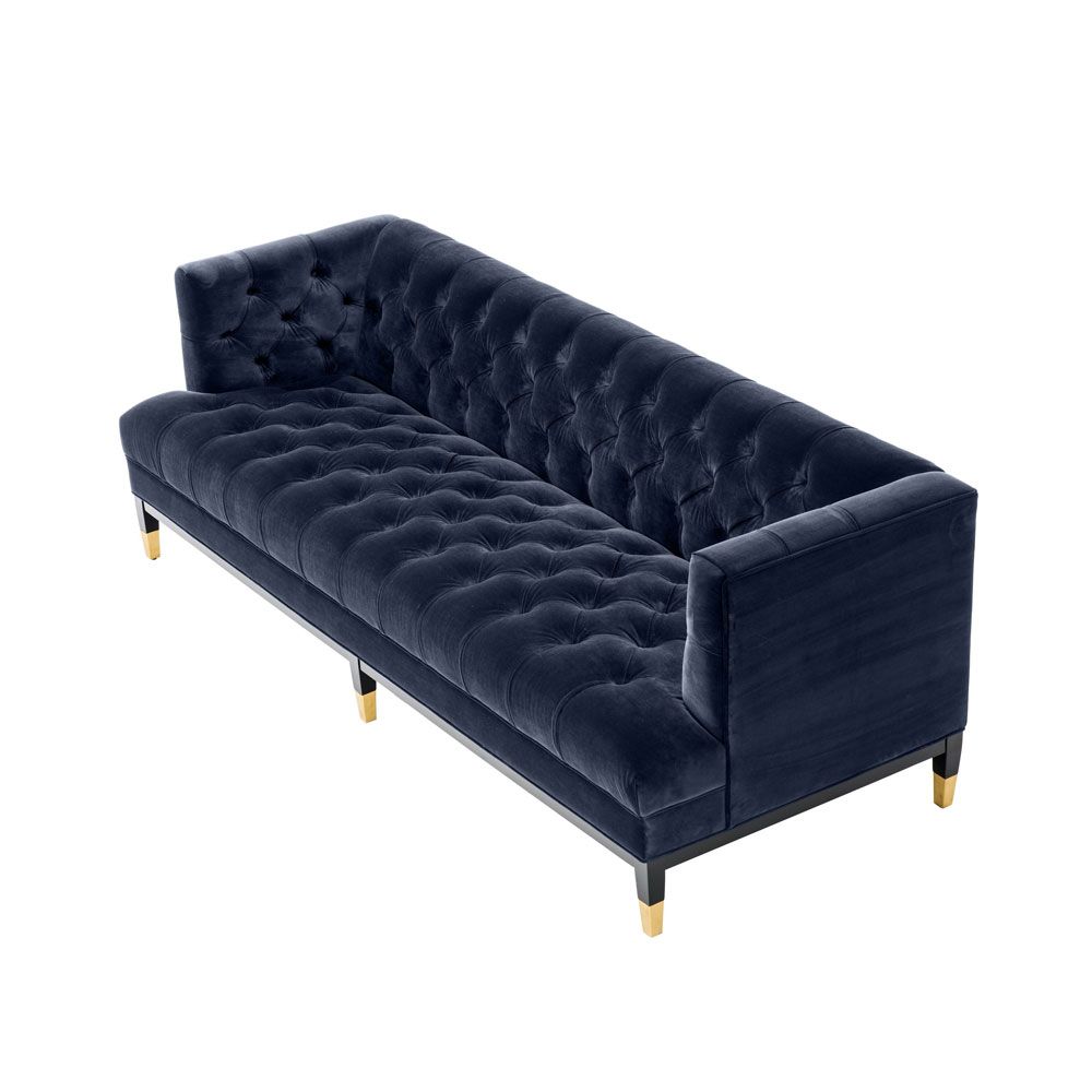 dark blue deep-buttoned sofa with velvet upholstery and black legs with gold accents