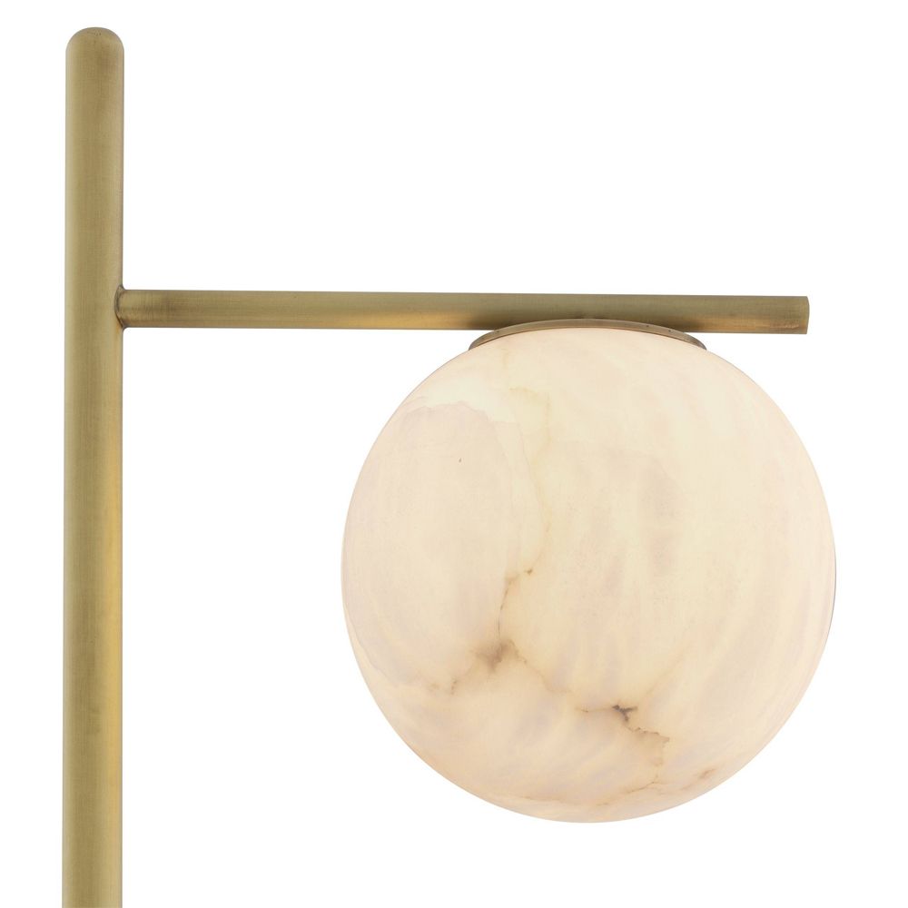 Luxurious antique brass floor lamp with alabaster lampshade on a black marble base