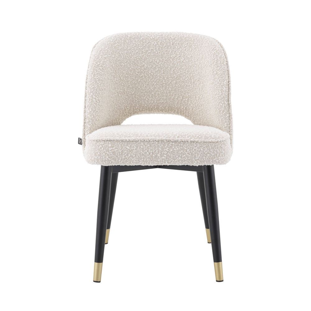 Stunning upholstered chair with black tapered legs and brass caps. 
