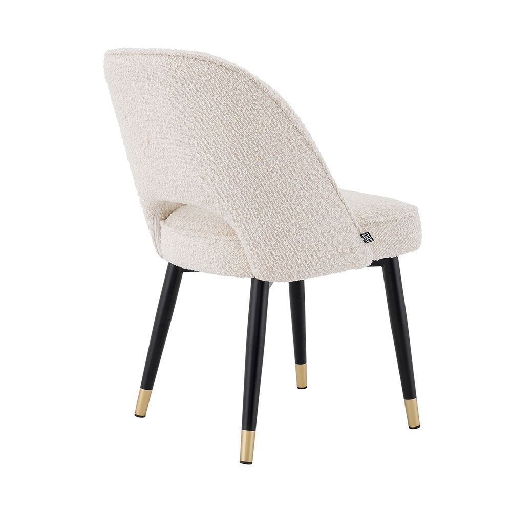 Stunning upholstered chair with black tapered legs and brass caps. 