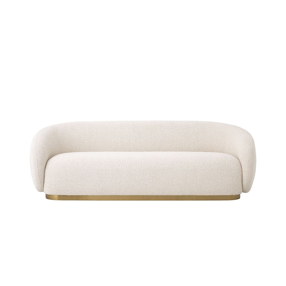 A sumptuous art deco inspired sofa with a brushed brass swivel base