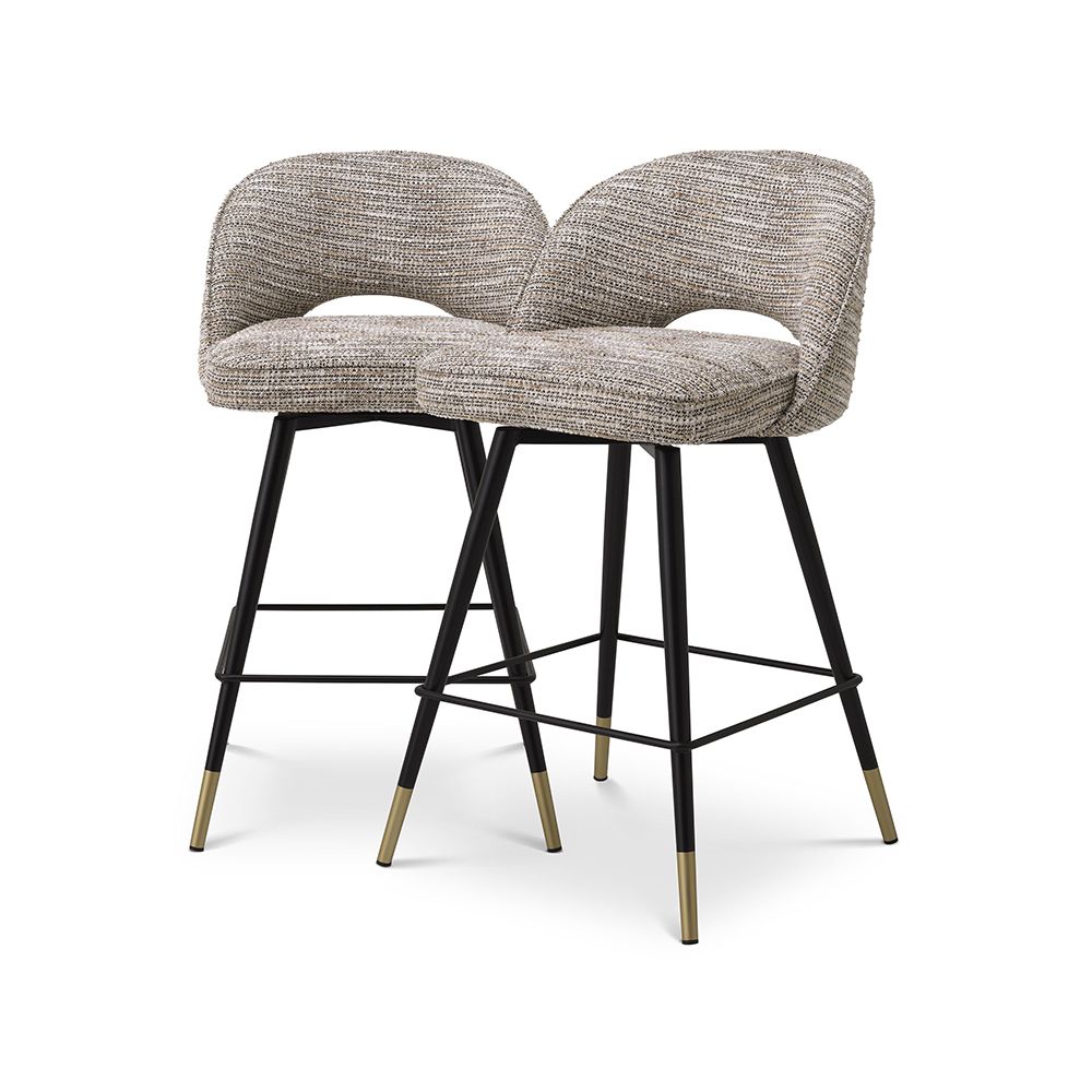 A luxury set of counter stools by Eichholtz with a Mademoiselle Beige upholstery and brass capped feet