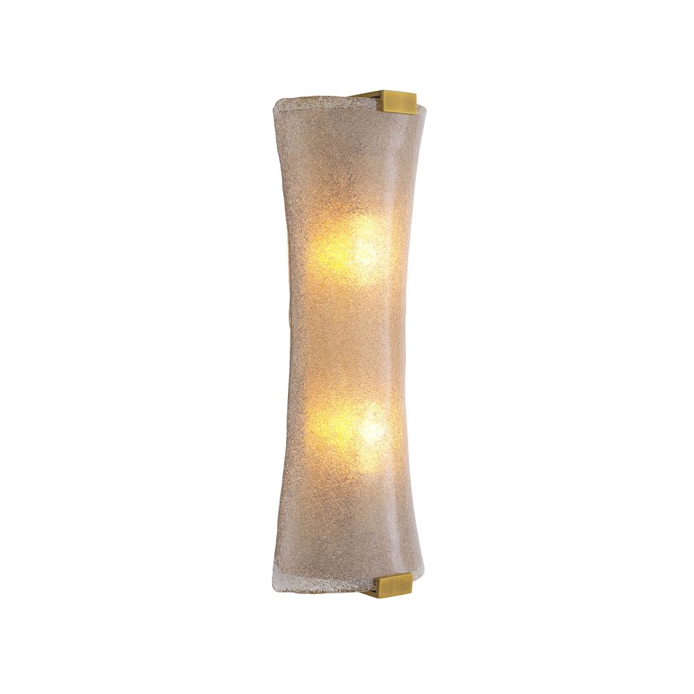 A unique wall lamp by Eichholtz with a hand blown glass curved shade and an antique brass finish