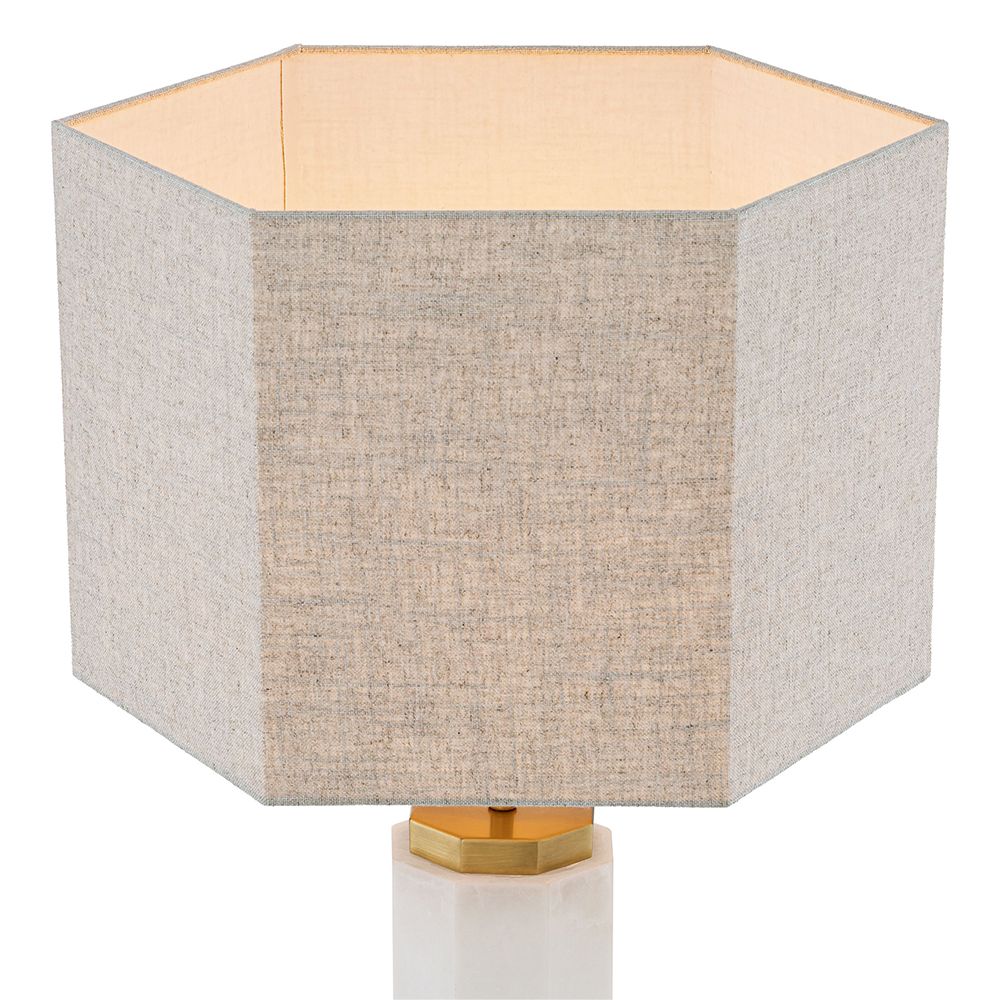 A glamorous side lamp by Eichholtz with an antique brass finish, octagonal alabaster body and linen mix lampshade