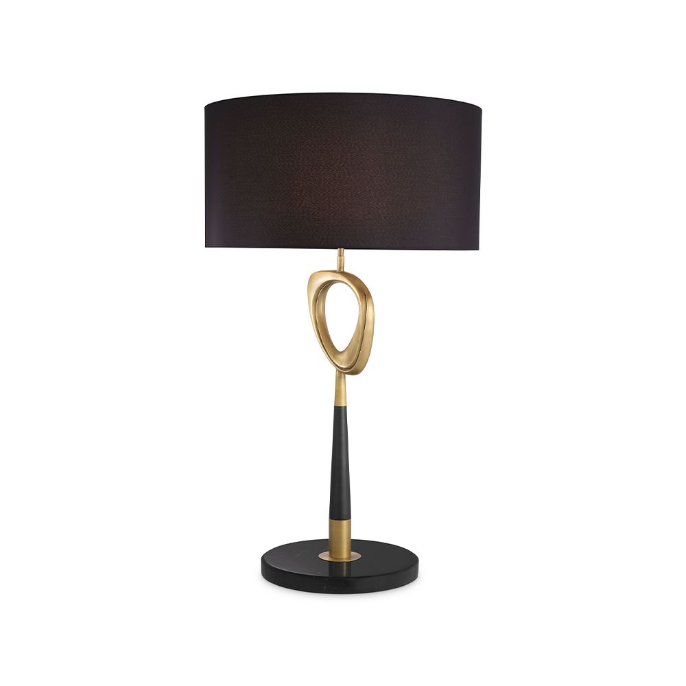 A contemporary table lamp by Eichholtz with a stylish design featuring an antique brass finish, an open free shape and a black cylindrical shade