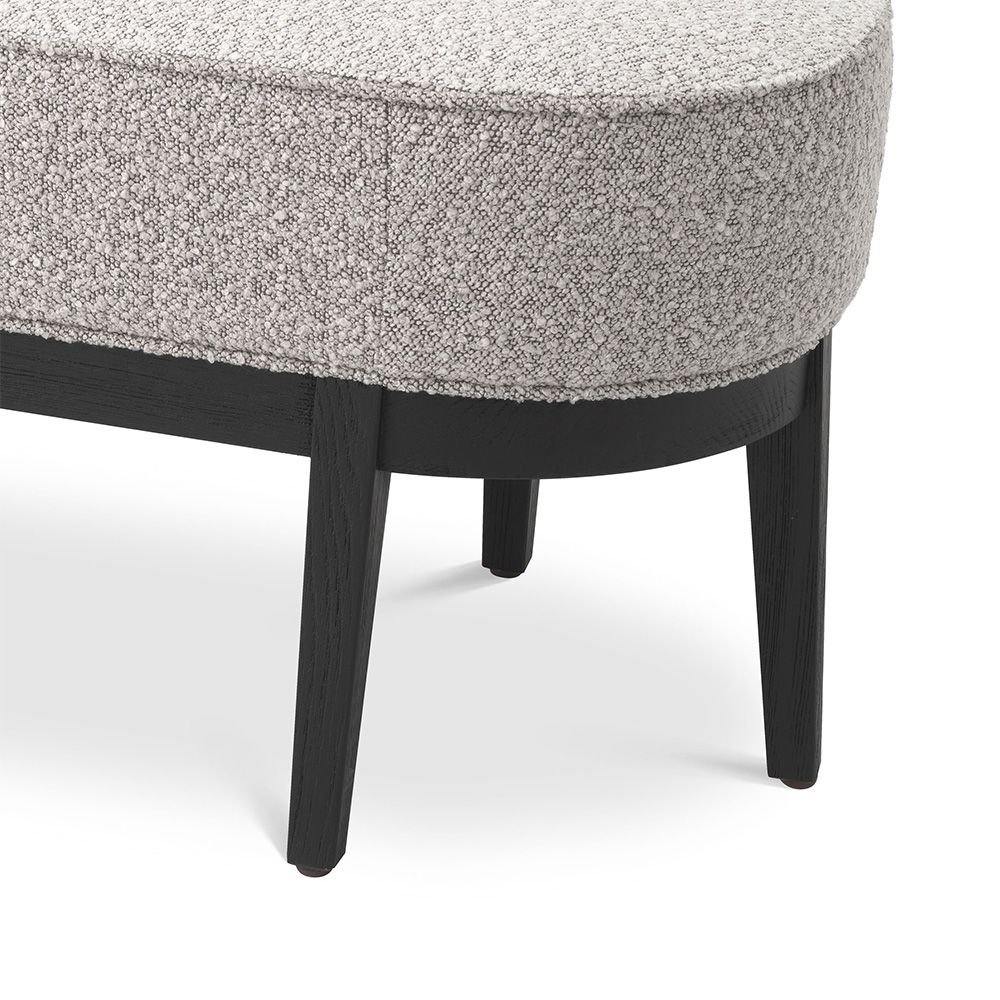 Grey boucle upholstered bench with gentle curves and three black tapered legs on either side