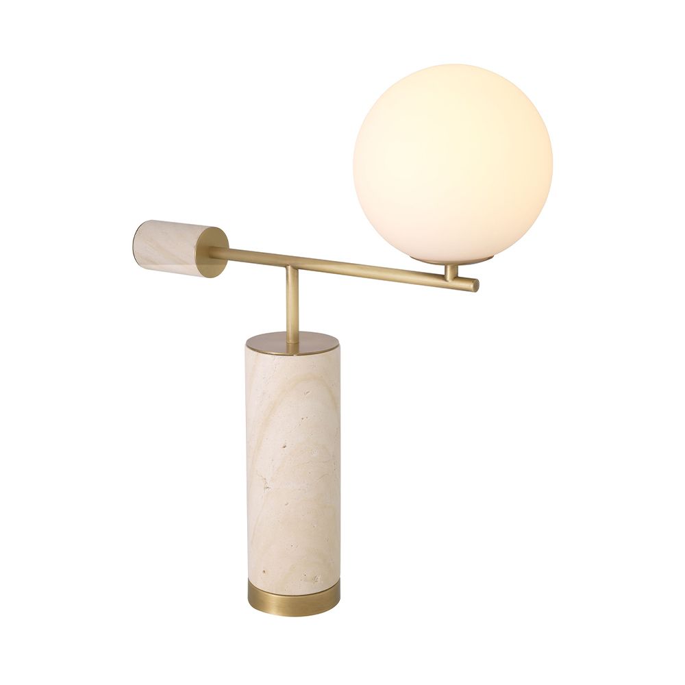 A sculptural side lamp by Eichholtz crafted from travertine with a spherical white glass shade and antique brass finish