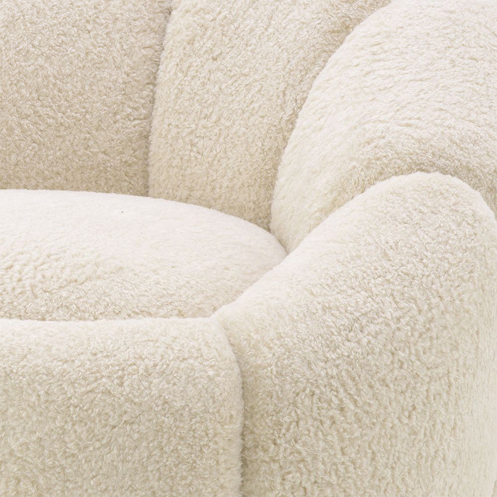 A beautiful swivel chair by Eichholtz with gentle curves, a soft-touch teddy upholstery and a brushed brass base