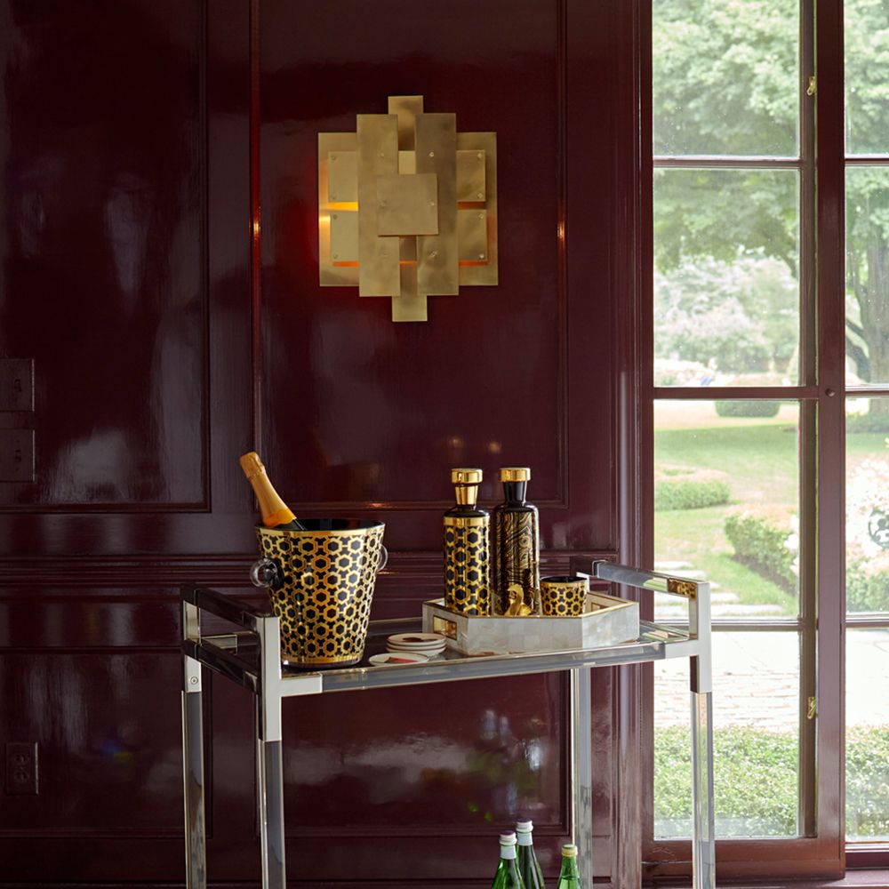 A glamorous industrial-style wall lamp in antique brass