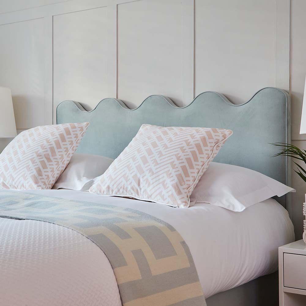 A luxurious velvet bed with a sculptural, coastal-inspired ripple headboard