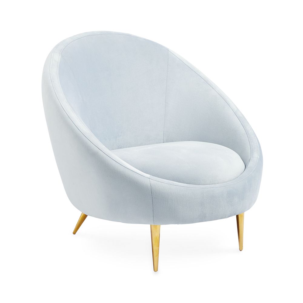 A stylish, modern armchair with light blue velvet upholstery and polished brass legs 