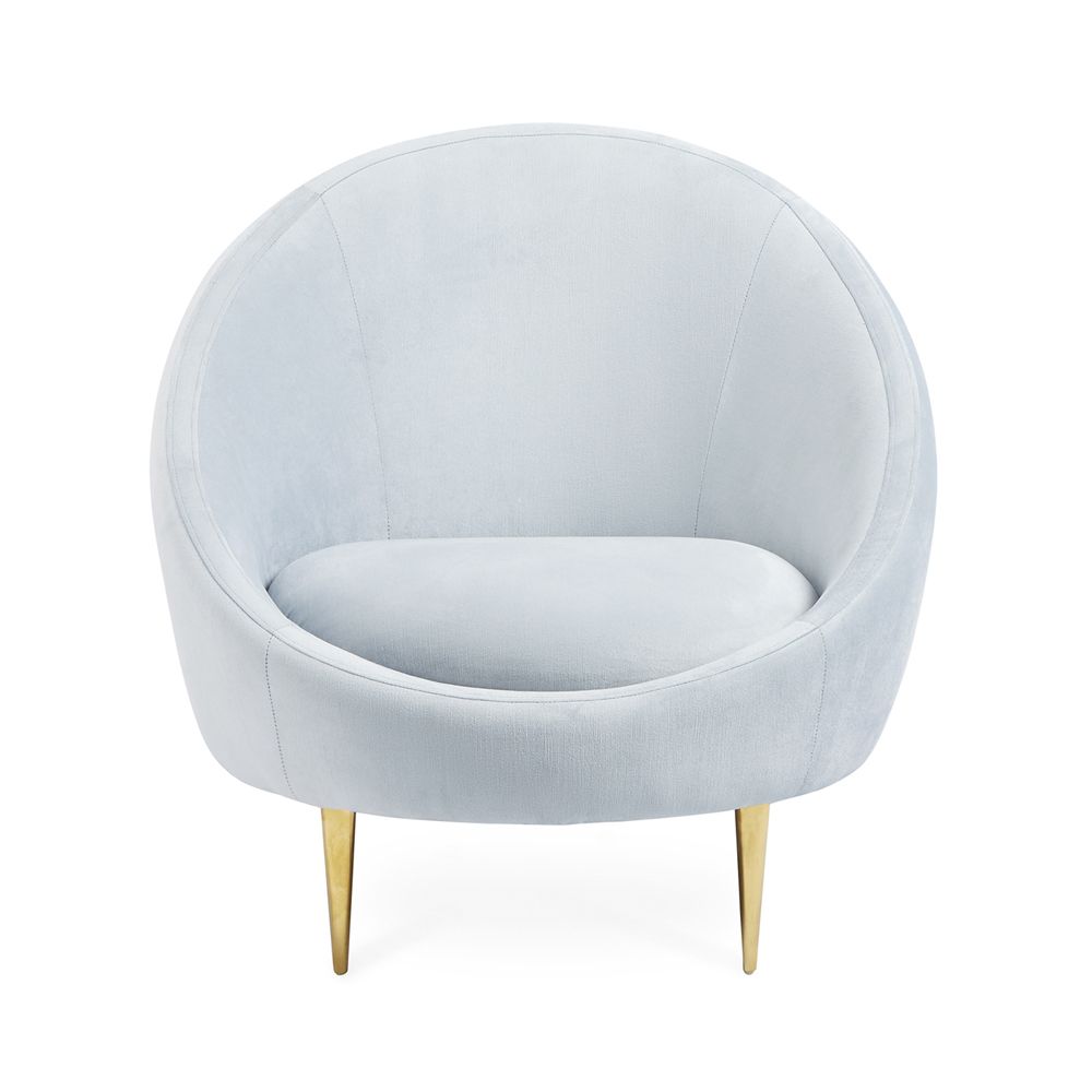 A stylish, modern armchair with light blue velvet upholstery and polished brass legs 