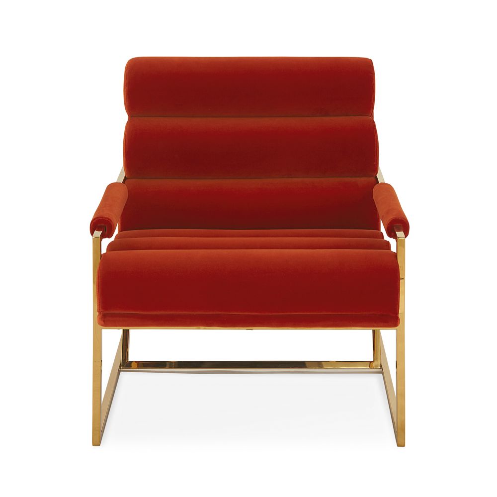 A mid-century modern inspired armchair with burnt orange velvet and a polished brass frame