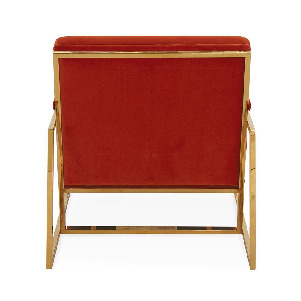A mid-century modern inspired armchair with burnt orange velvet and a polished brass frame