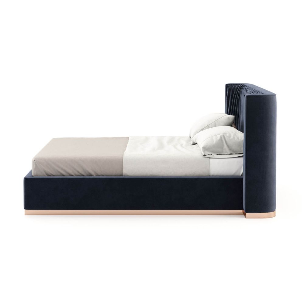 An elegant modern bed with vintage pleating and a copper plinth. Pictured in Vienna Deep Blue.