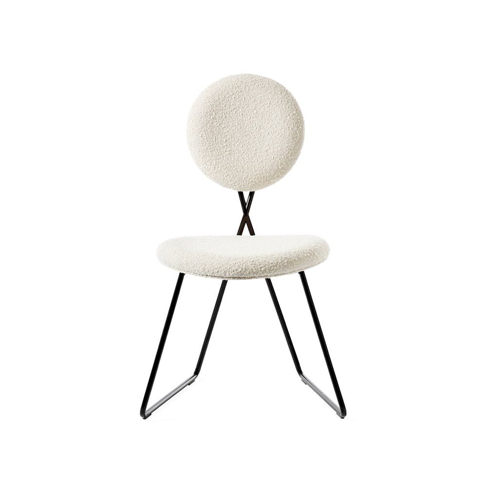 Stylish dining chair upholstered in white fabric with a sleek black frame