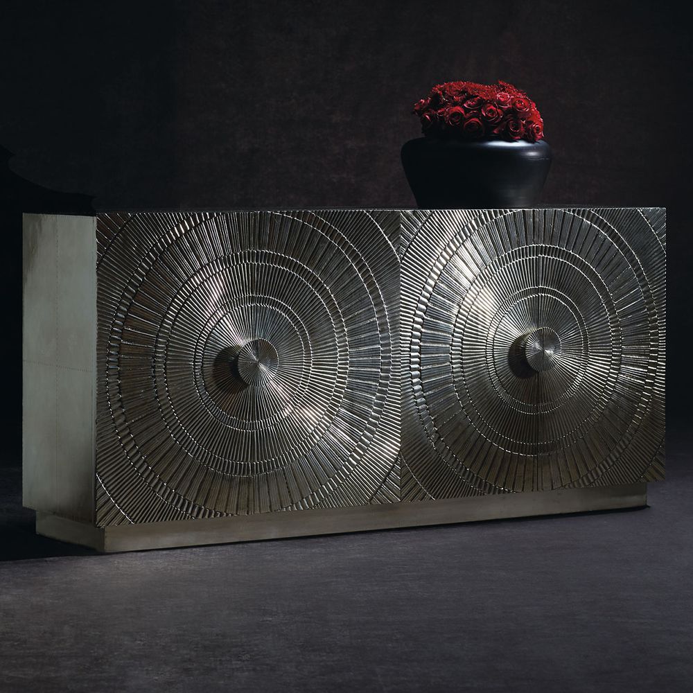 A glamorous four door silver cabinet with an embossed circular pattern and internal shelving 