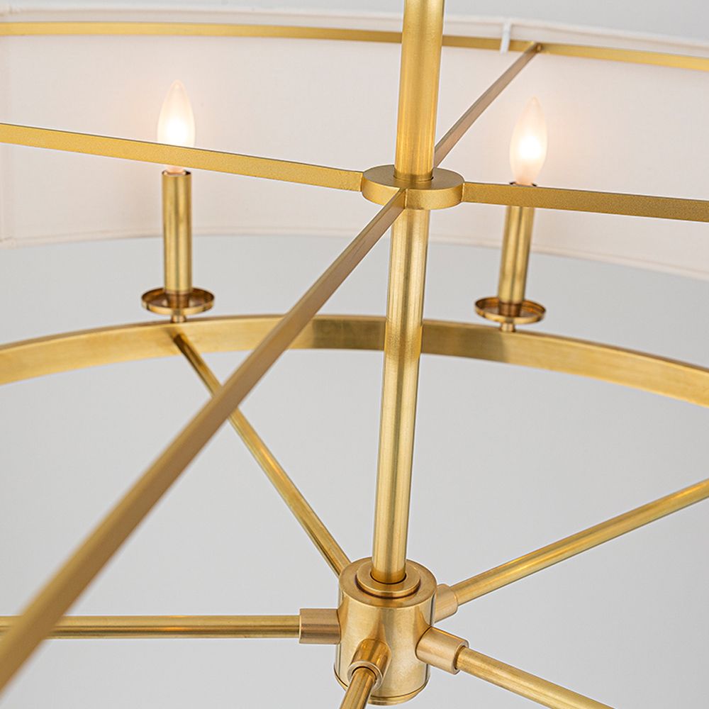 An elegant oval ceiling pendant in aged brass with an off-white linen lampshade 