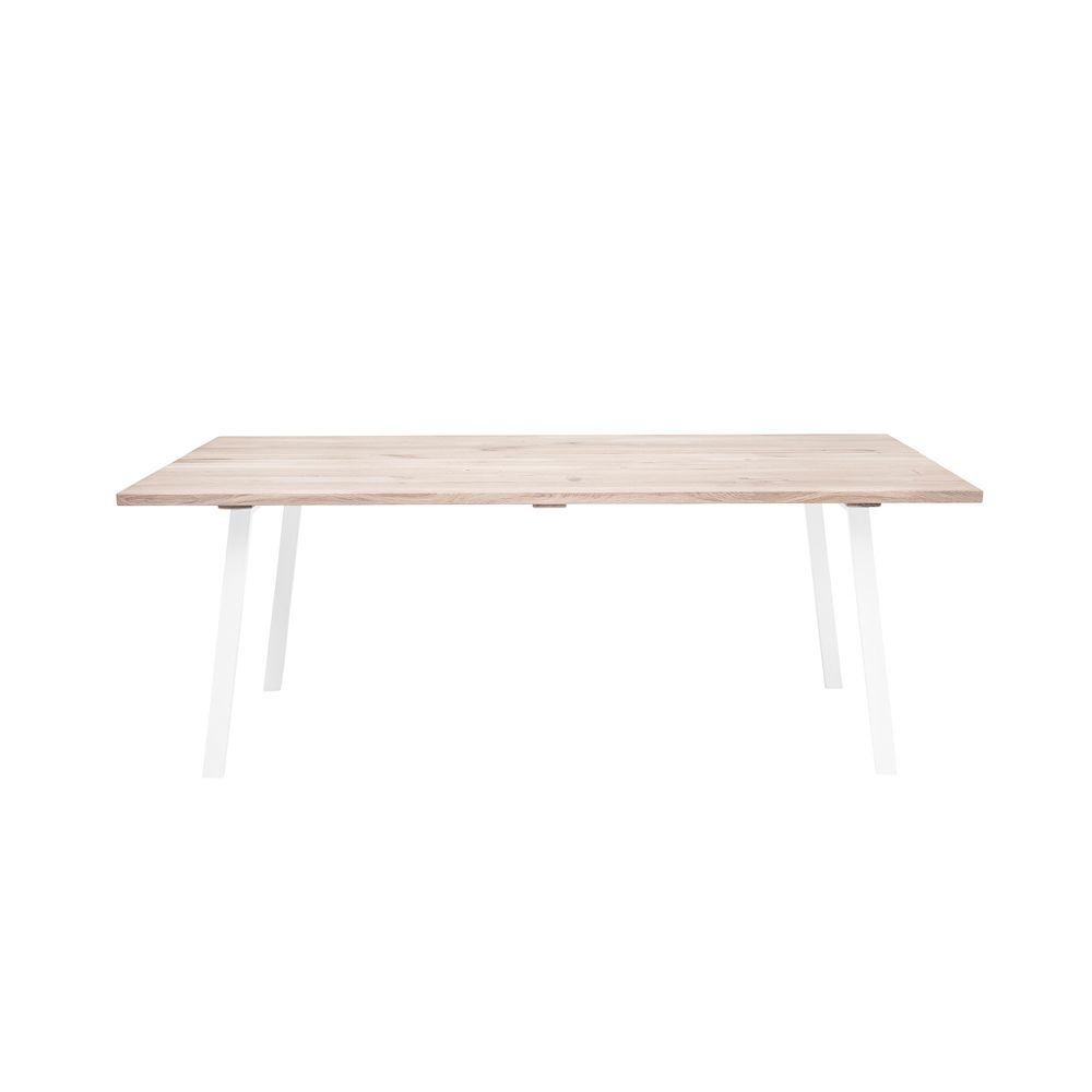 A stylish natural oak dining table with white iron legs