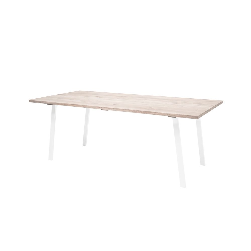 A stylish natural oak dining table with white iron legs