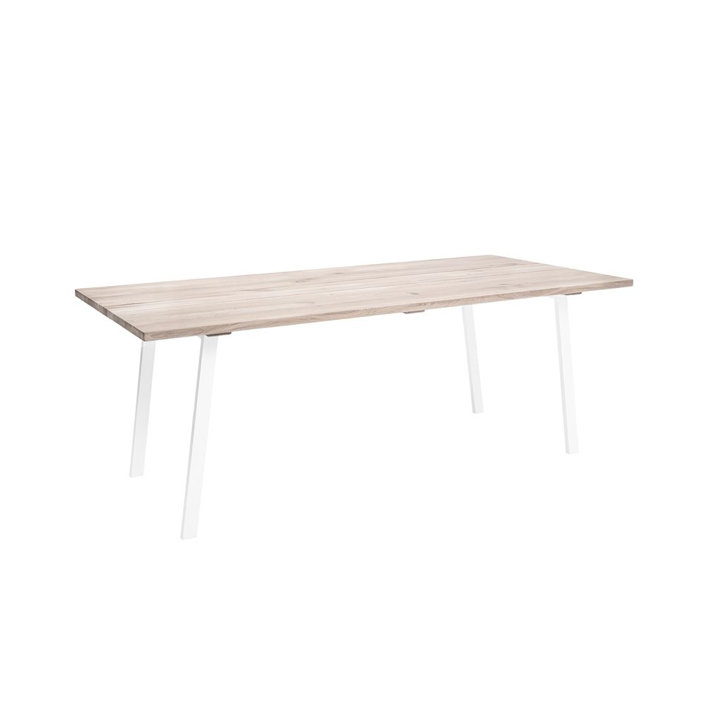 A stylish natural oak dining table with white iron legs