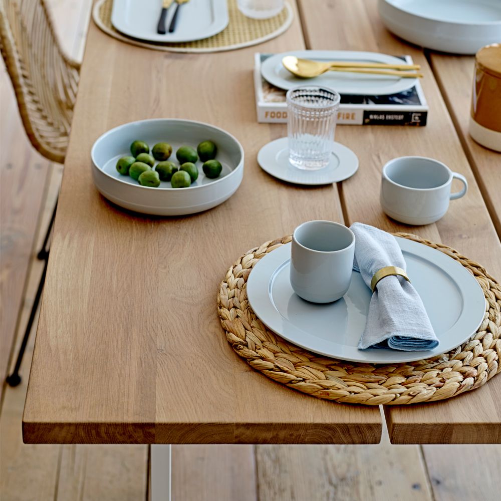 A stylish natural oak dining table with white iron legs