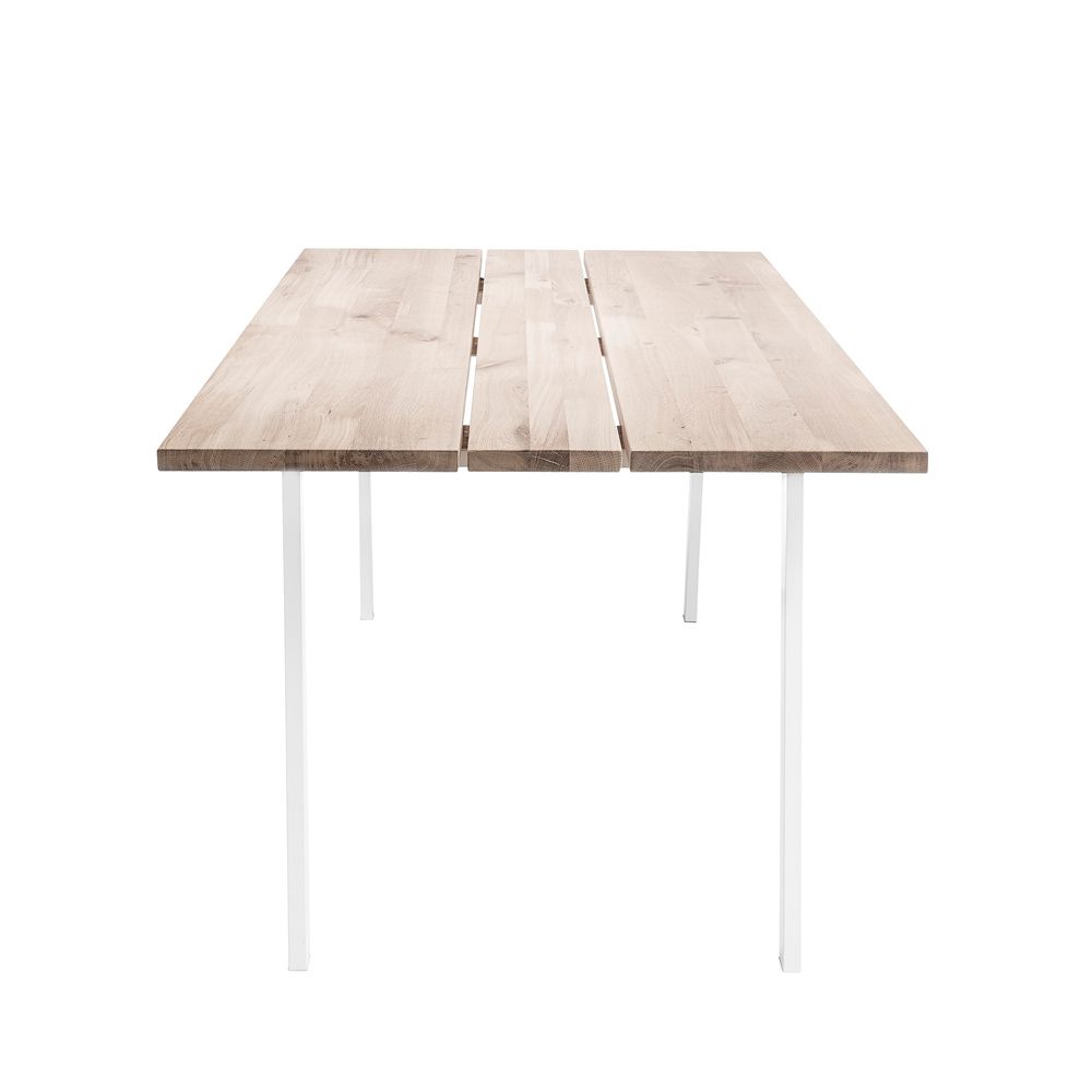 A stylish natural oak dining table with white iron legs