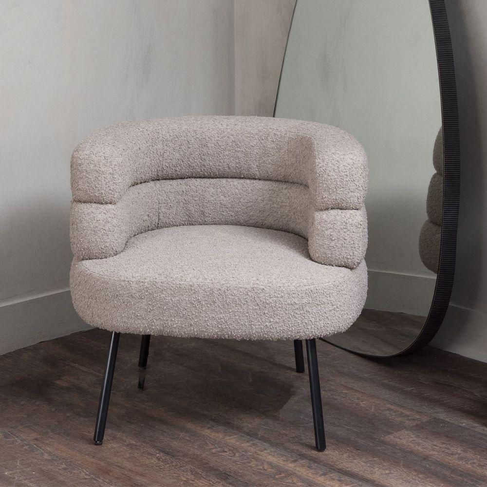 A Mid-Century Modern armchair with Art-Deco influences, a stylish silhouette and a taupe bouclé upholstery 